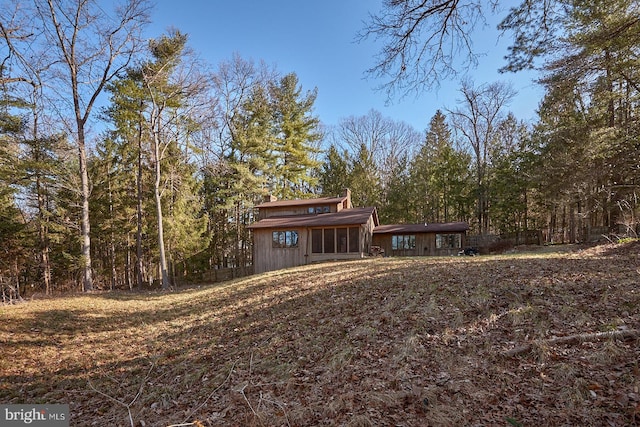 view of yard featuring a forest view and fence