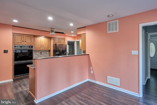 kitchen with visible vents, tasteful backsplash, black appliances, and dark wood-style flooring