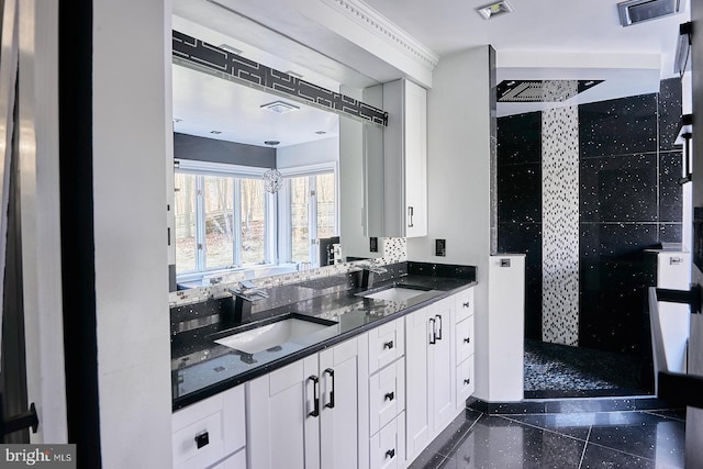 kitchen with white cabinets, visible vents, and a sink