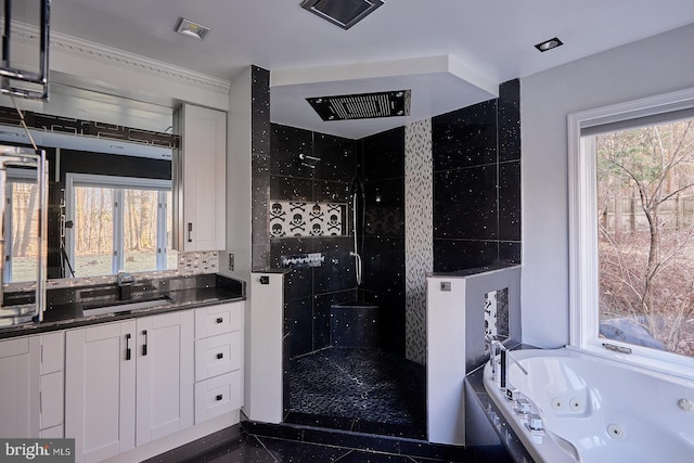 bathroom featuring tasteful backsplash, vanity, a jetted tub, and a shower stall