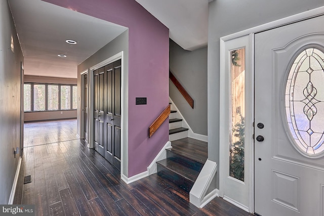 foyer entrance featuring baseboards, dark wood-style floors, and stairs