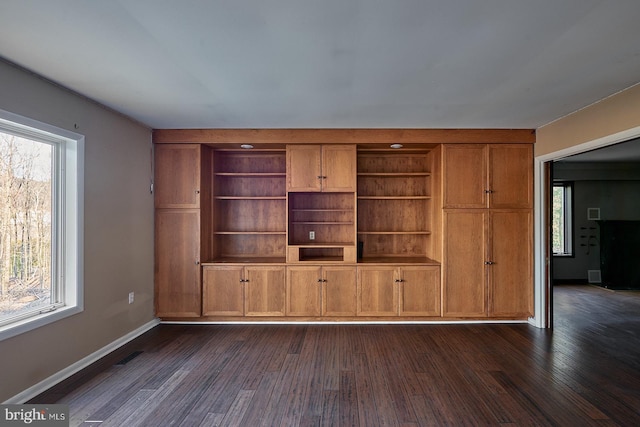 unfurnished living room featuring visible vents, baseboards, and dark wood-style flooring