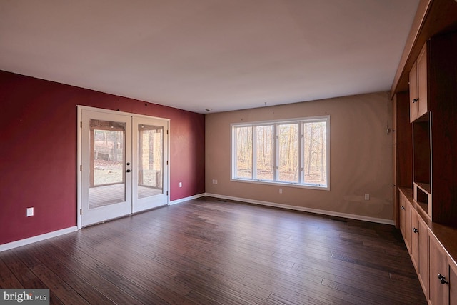 unfurnished living room featuring french doors, baseboards, and dark wood finished floors