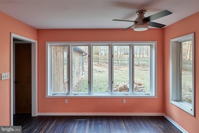 interior space featuring ceiling fan, dark wood-type flooring, and baseboards