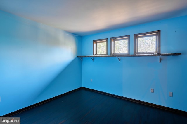 spare room with dark wood-style floors and baseboards