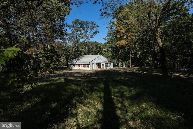 exterior space with a view of trees and a front lawn