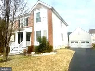 view of front of house featuring a detached garage, an outbuilding, and a front yard