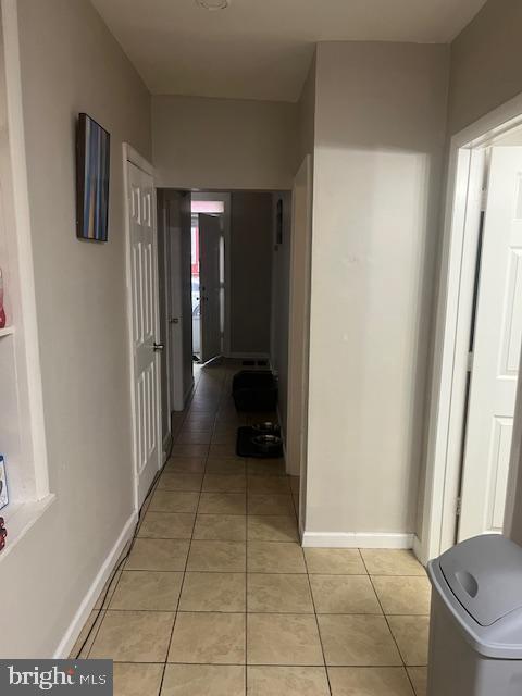 hall with light tile patterned floors and baseboards