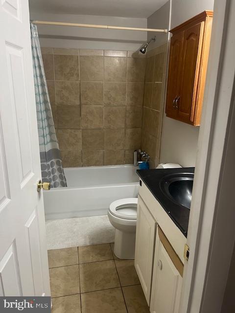 bathroom featuring vanity, tile patterned floors, toilet, and shower / bath combo with shower curtain