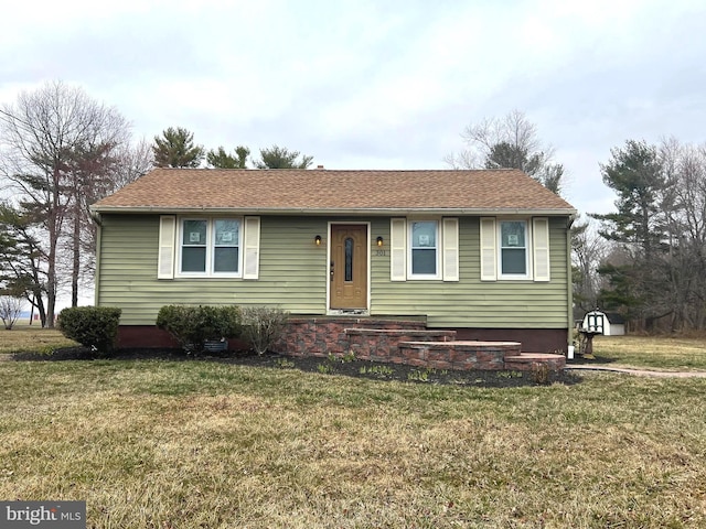 view of front of home featuring roof with shingles and a front lawn