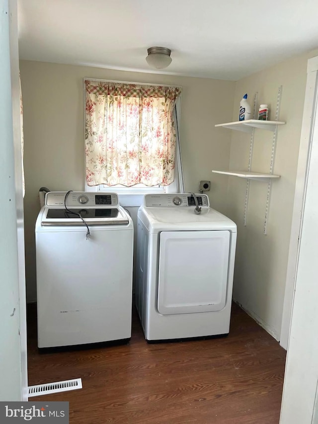 laundry area featuring separate washer and dryer, dark wood-style floors, and laundry area