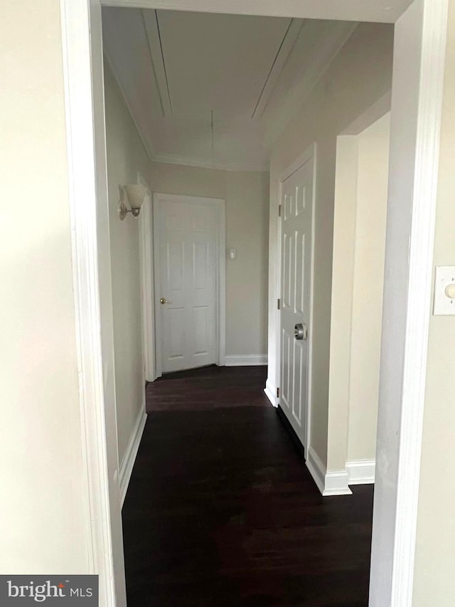 hallway with baseboards, attic access, and dark wood-style flooring