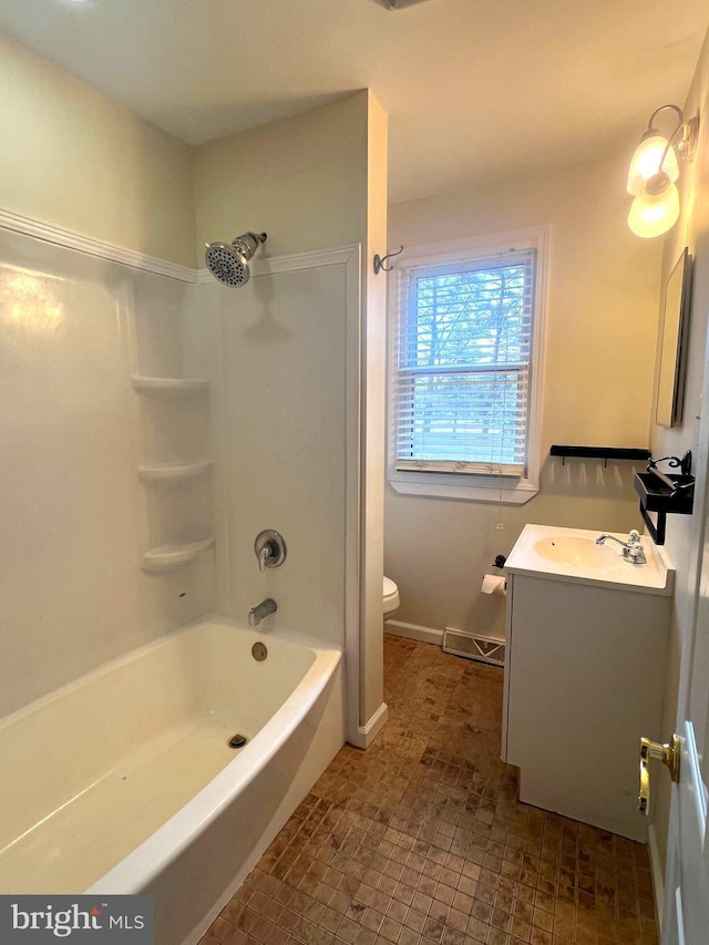 bathroom with baseboards, toilet, vanity, and shower / bathing tub combination