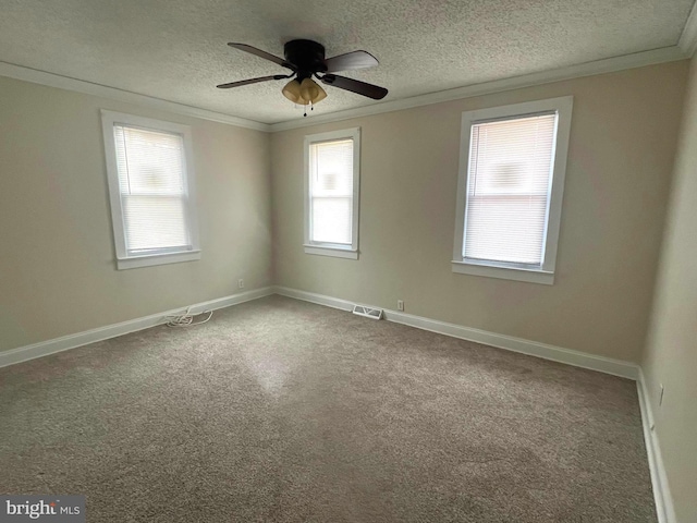 carpeted empty room with baseboards, a textured ceiling, ornamental molding, and a ceiling fan