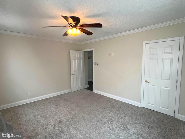 unfurnished bedroom featuring carpet flooring, a textured ceiling, crown molding, and baseboards