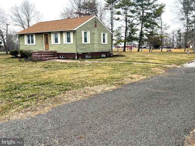 view of front of home featuring a front lawn and roof with shingles