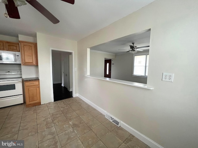 kitchen with visible vents, a ceiling fan, white appliances, light tile patterned floors, and baseboards