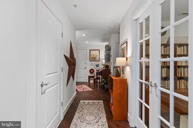 corridor with dark wood finished floors, recessed lighting, and french doors