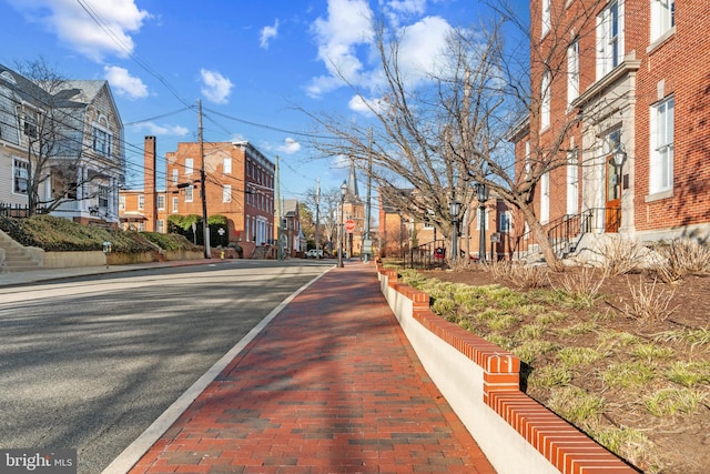 view of street with street lights, traffic signs, curbs, and sidewalks