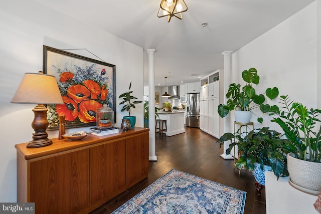 interior space with decorative columns and dark wood-type flooring