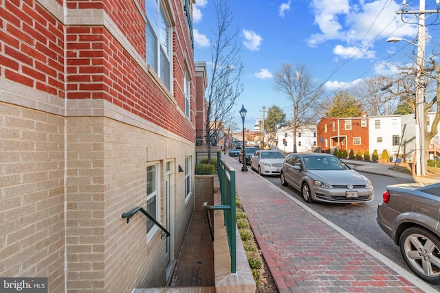 view of street with a residential view, curbs, street lighting, and sidewalks