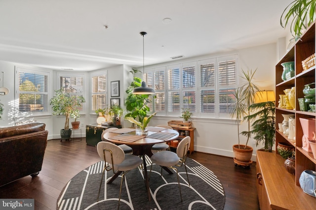 dining space featuring wood finished floors, visible vents, and baseboards