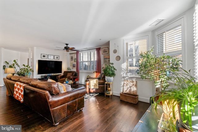 living area with visible vents, dark wood-type flooring, and ceiling fan