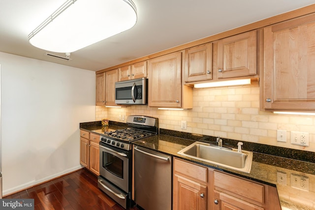 kitchen featuring visible vents, a sink, tasteful backsplash, dark wood finished floors, and appliances with stainless steel finishes