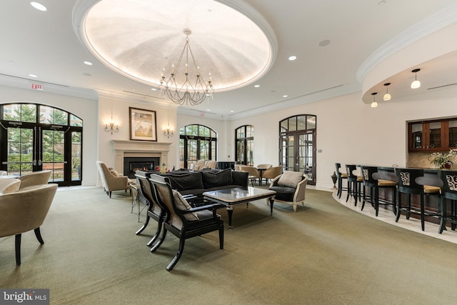 carpeted living room featuring a tray ceiling, plenty of natural light, crown molding, and french doors