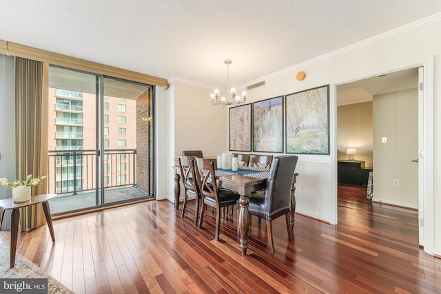 dining area featuring baseboards, an inviting chandelier, wood-type flooring, a textured ceiling, and crown molding