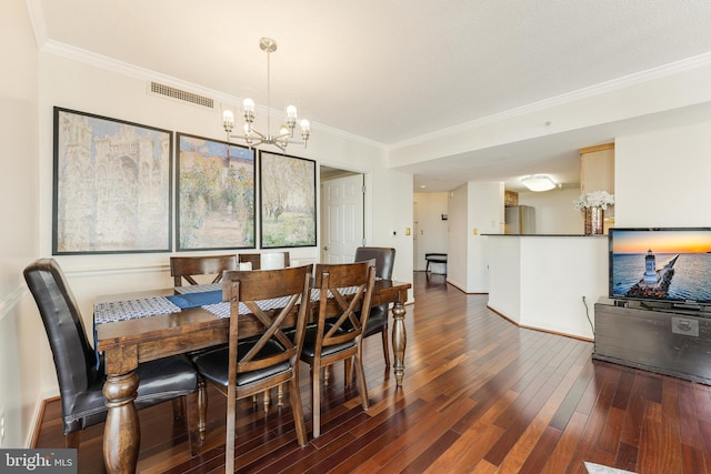 dining space featuring visible vents, ornamental molding, wood finished floors, an inviting chandelier, and baseboards