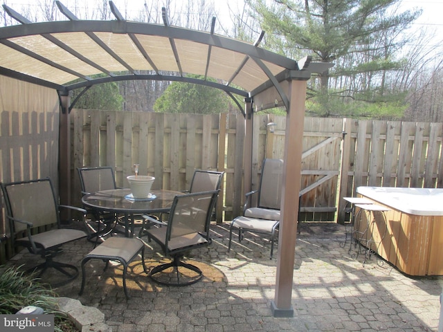 view of patio / terrace featuring a gate, a hot tub, a pergola, and fence