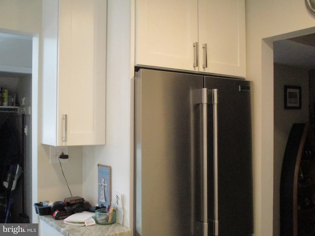 kitchen featuring light countertops, white cabinets, and high quality fridge