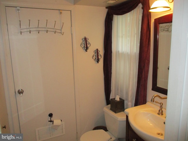 half bathroom with visible vents, toilet, and vanity