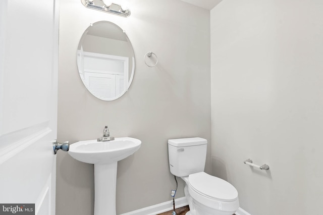 bathroom featuring toilet and baseboards