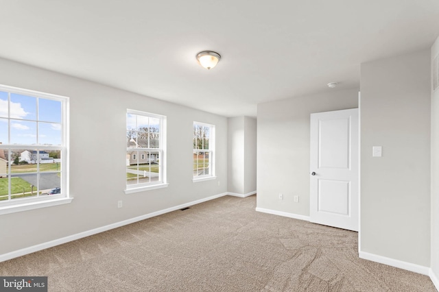 carpeted empty room with baseboards