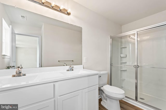 bathroom with a shower stall, toilet, and a sink