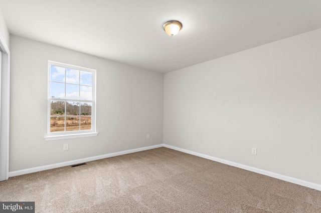 carpeted spare room with baseboards and visible vents