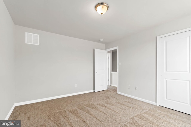 unfurnished bedroom featuring visible vents, baseboards, and carpet flooring