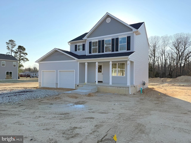 view of front facade with a porch, an attached garage, and dirt driveway