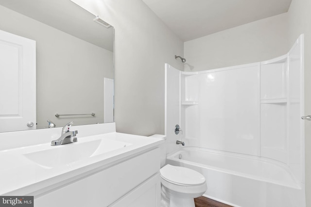 full bathroom with visible vents, toilet, wood finished floors,  shower combination, and vanity