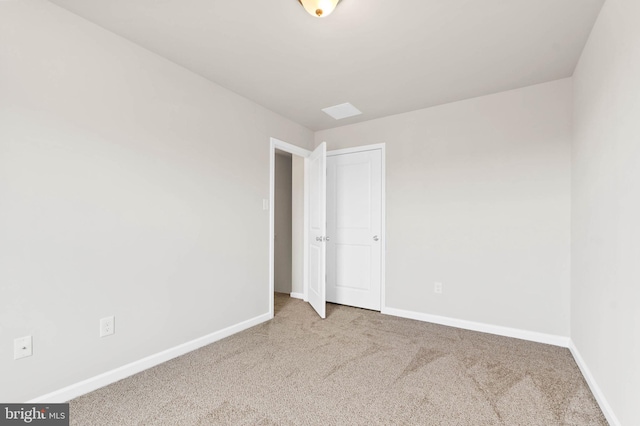 spare room featuring carpet flooring and baseboards