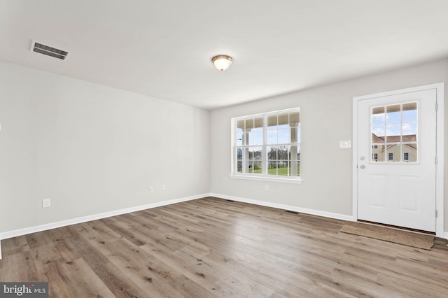 foyer entrance featuring wood finished floors, visible vents, and baseboards