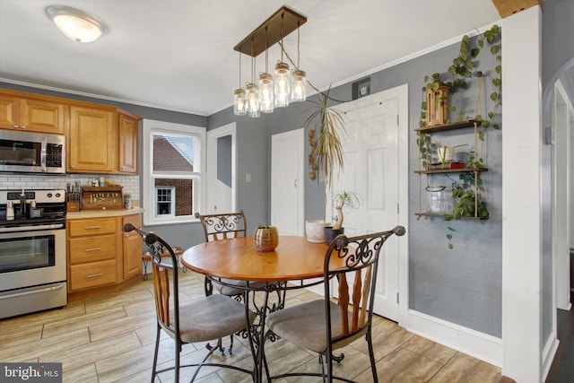 dining room featuring crown molding, arched walkways, baseboards, and wood finish floors