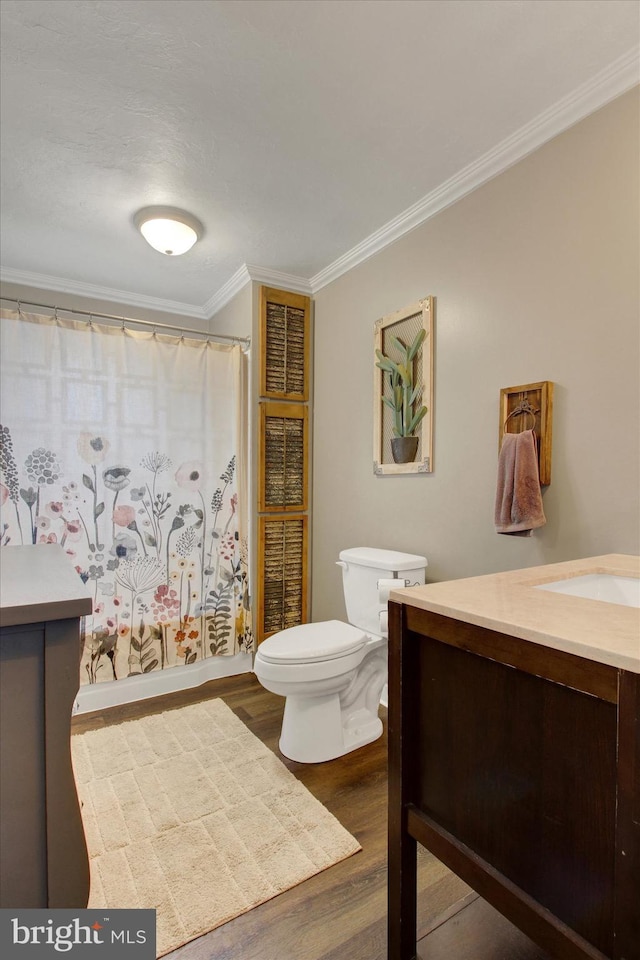 full bathroom with crown molding, toilet, a shower with shower curtain, wood finished floors, and vanity