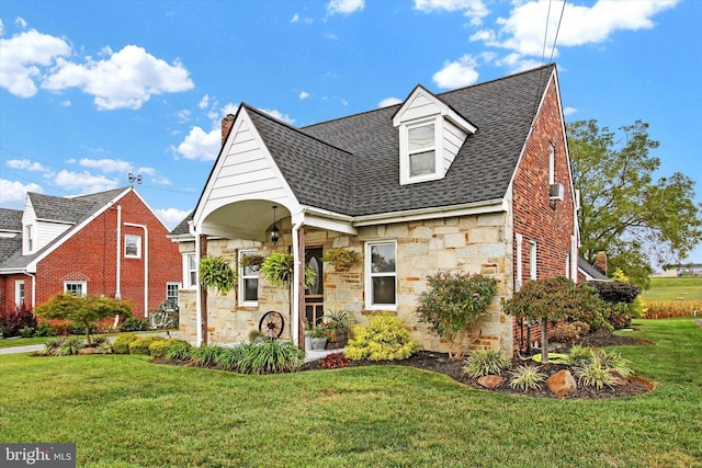 view of front of home with a front yard, stone siding, and a shingled roof