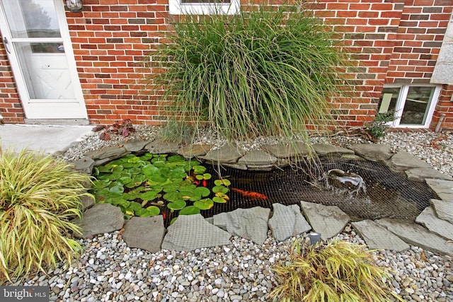 details featuring brick siding and a garden pond