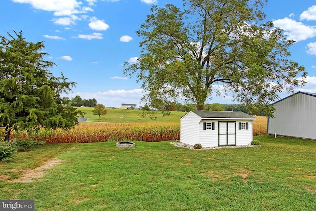 view of yard with a shed, an outdoor fire pit, and an outdoor structure