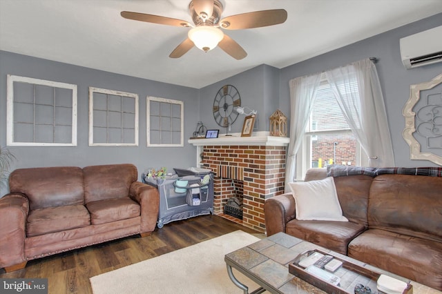 living area featuring a fireplace, an AC wall unit, a ceiling fan, and wood finished floors