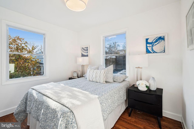 bedroom featuring baseboards and dark wood-style flooring